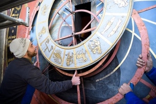 A man starts to remove the clock face of the Zytglogge in Bern.