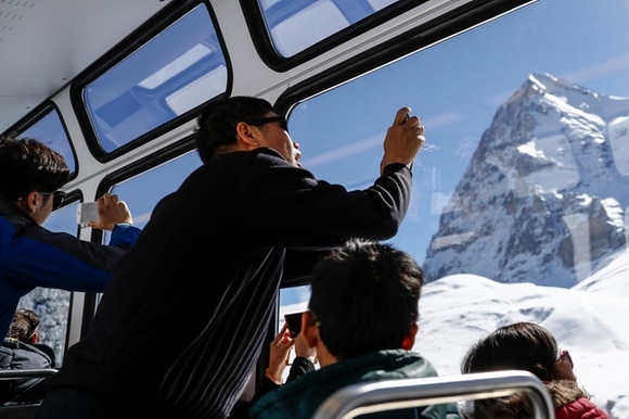Tourist takes picture of mountain from a train