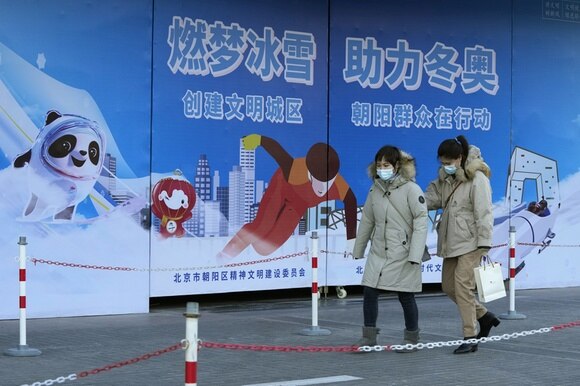 امرأتان تسيران أمام ملصقات إشهارية لدورة الألعاب الأولمبية الشتوية في مدينة بكين